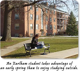 An Earlham student takes advantage of an early spring thaw to enjoy studying outside.