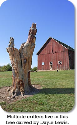 Multiple critters live in this tree carved by Dayle Lewis.