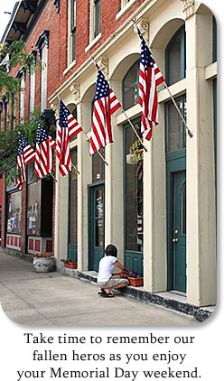 Flags decorate storefront. "Take time to enjoy our fallen heros as you enjoy your Memorial Day weekend.