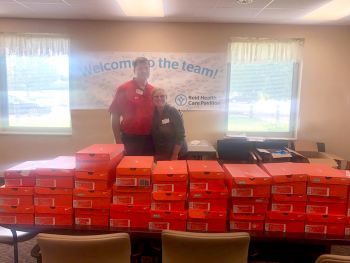 Supplied Image: Reid Employees behind shoe boxes.