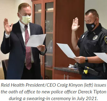 Supplied Photo:  Reid Health President/CEO Craig Kinyon (left) issues the oath of office to new police officer Dereck Tipton during a swearing-in ceremony in July 2021.