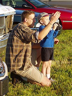 Dad showing son how to use binoculars.