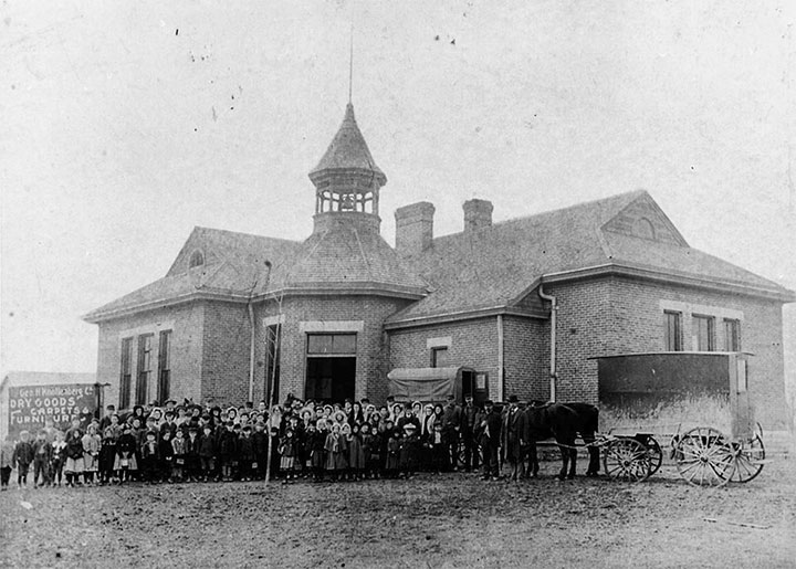 Supplied Photo: Whitewater School with crowd and horse drawn wagon in front of it.