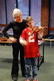 Photo: Young man tries his hand at the violin.